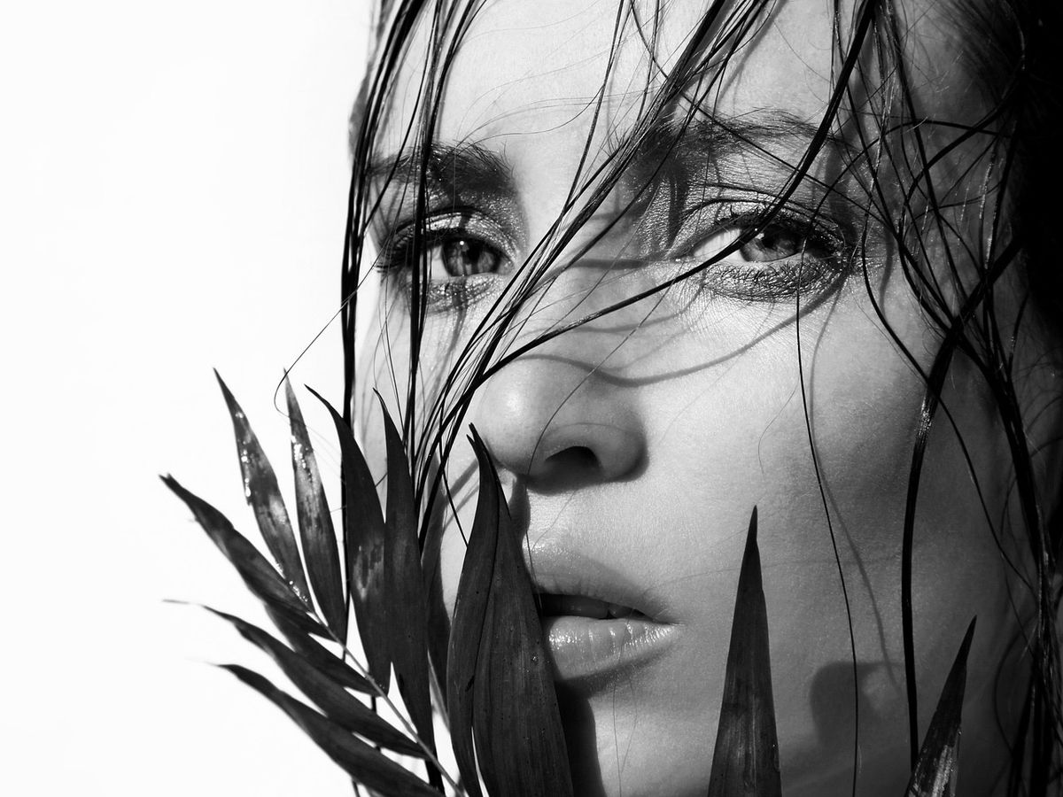 Black-and-white portrait of a woman with wet, glossy hair