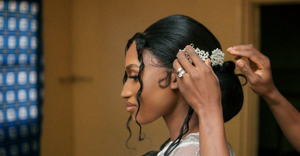 A bride getting her hair styled with a beautiful accessory, preparing for her wedding.
